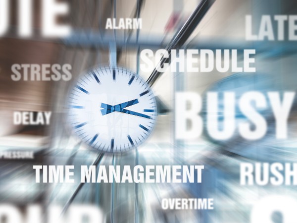 Bahnhofuhr mit verschiedenen Worten ("STRESS", "DELAY", "BUSY", "TIME MANAGEMENT", "SCHEDULE", "OVERTIME", "RUSH", "ALARM" und "LATE") rundherum